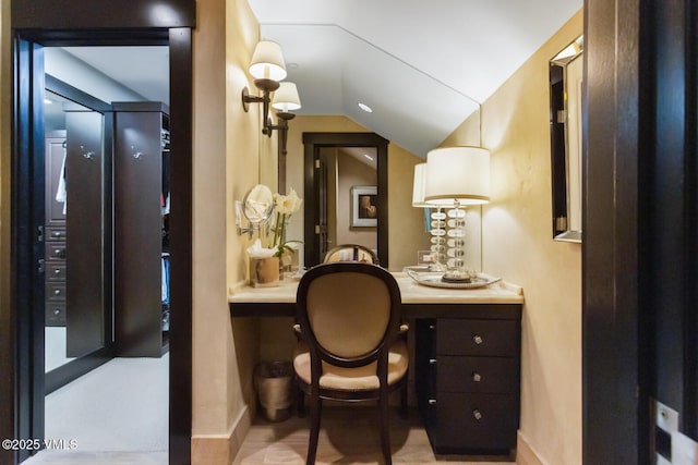 bathroom with vaulted ceiling and baseboards