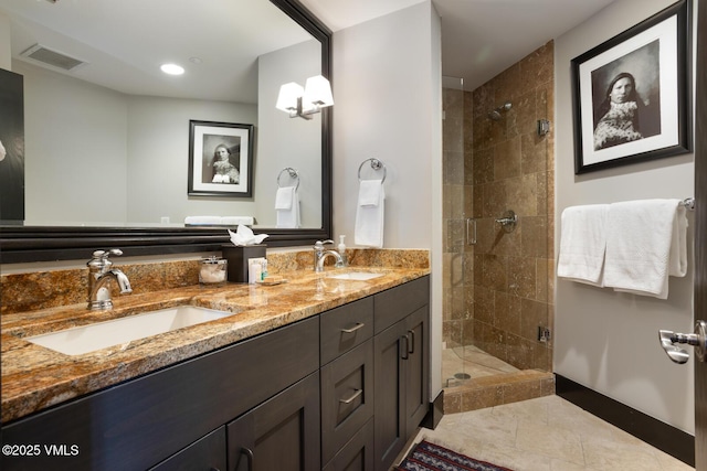 full bath featuring double vanity, a stall shower, visible vents, and a sink