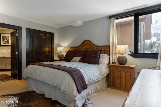 carpeted bedroom with visible vents and a closet