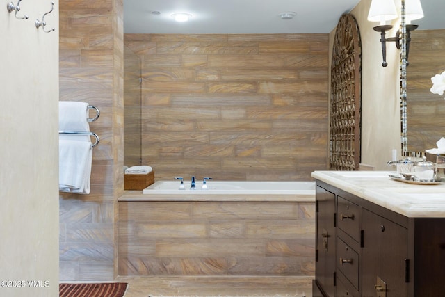 bathroom with a garden tub and vanity