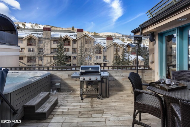 view of patio with a balcony, a hot tub, a grill, and a mountain view