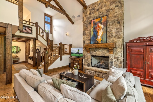 922 June Creek Rd, Edwards, CO 81632 - living area featuring high vaulted ceiling, beamed ceiling, wood finished floors, a stone fireplace, and baseboards