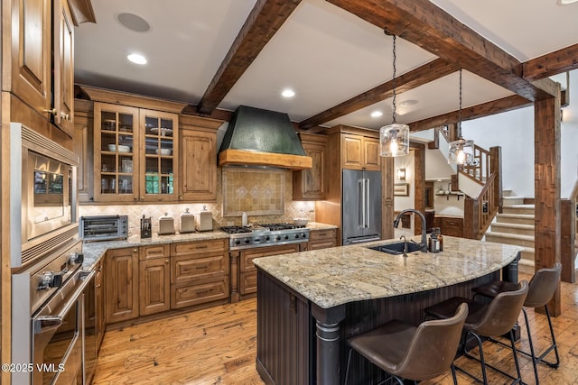 922 June Creek Rd, Edwards, CO 81632 - kitchen with appliances with stainless steel finishes, premium range hood, a sink, light stone countertops, and backsplash