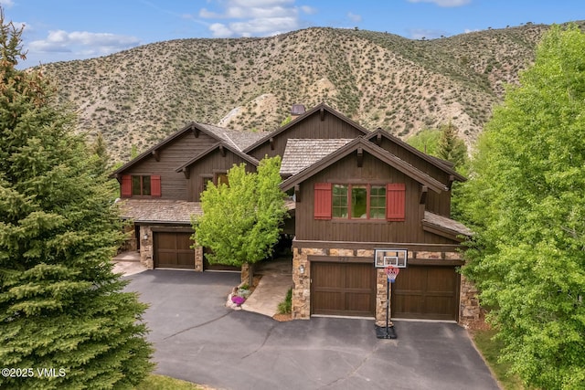 922 June Creek Rd, Edwards, CO 81632 - view of front of property with stone siding, an attached garage, and a mountain view