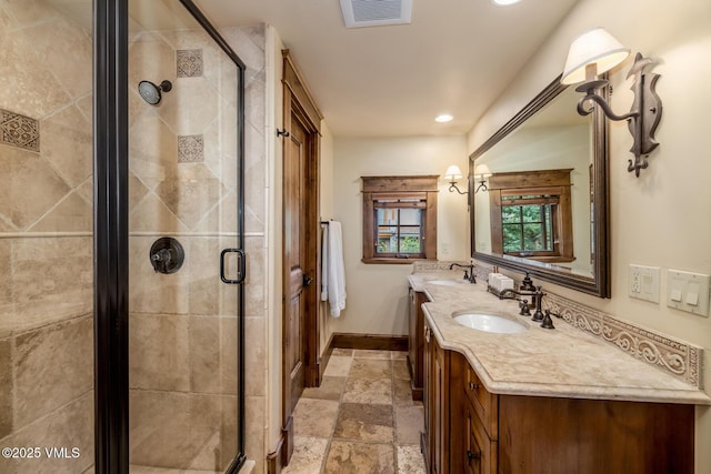 922 June Creek Rd, Edwards, CO 81632 - full bathroom featuring stone tile floors, double vanity, baseboards, a shower stall, and recessed lighting