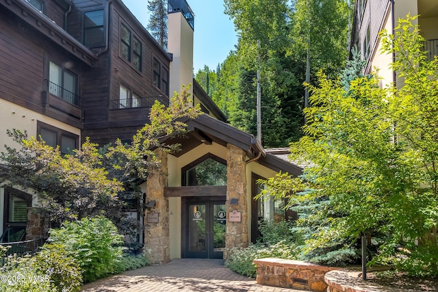 600 Vail Valley Dr Unit 310, Vail, CO 81657 - entrance to property with french doors, stone siding, and a chimney