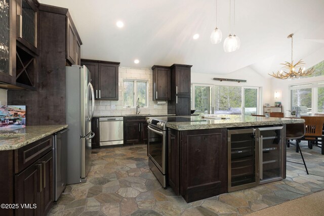 4515 Bighorn Rd, Vail, CO 81657 - kitchen featuring stainless steel appliances, a sink, a chandelier, dark brown cabinetry, and a center island