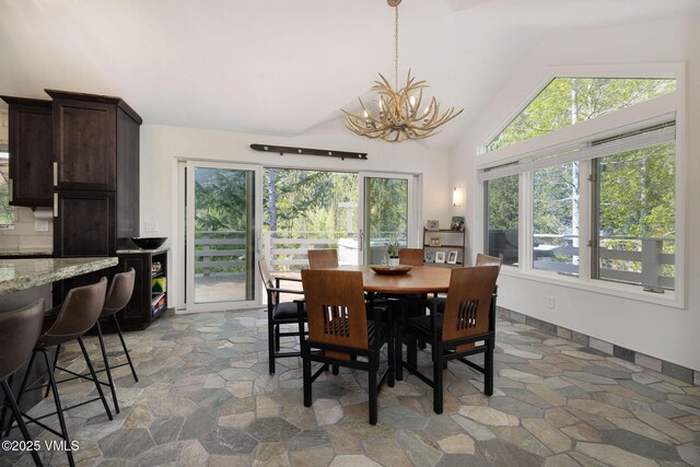 4515 Bighorn Rd, Vail, CO 81657 - dining space with light stone finish flooring, a chandelier, and high vaulted ceiling