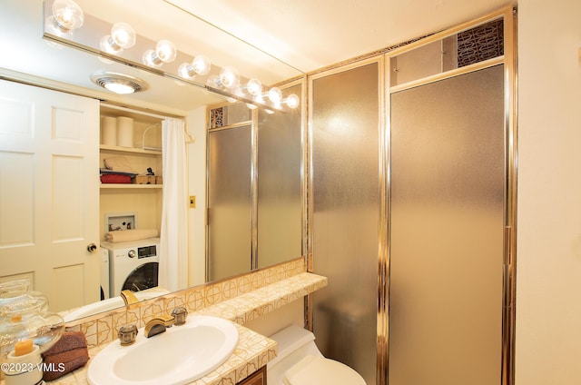 bathroom featuring vanity, washer / clothes dryer, and an enclosed shower