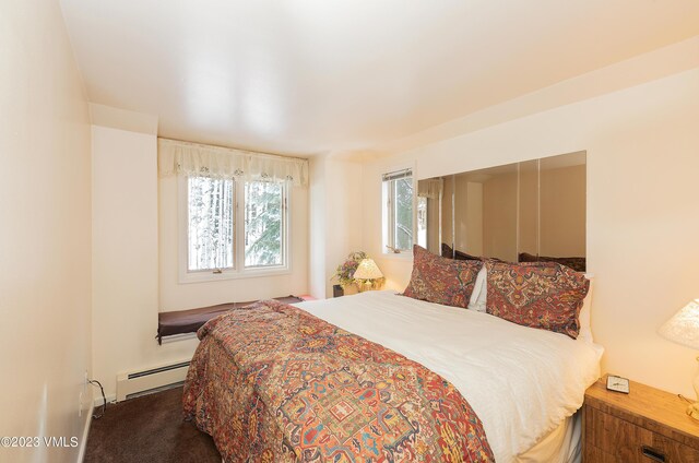 carpeted bedroom featuring baseboard heating