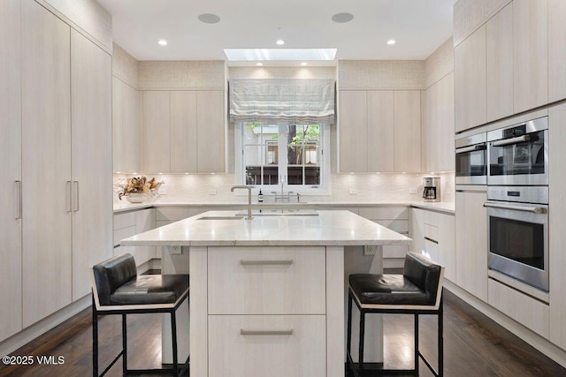 450 Steele St, Denver, CO 80236 - kitchen featuring modern cabinets, double oven, a breakfast bar, dark wood-type flooring, and backsplash