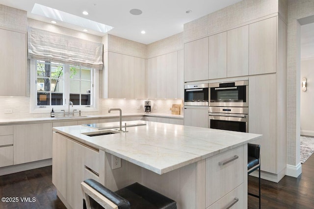 450 Steele St, Denver, CO 80236 - kitchen featuring modern cabinets, double oven, a breakfast bar, a skylight, and recessed lighting