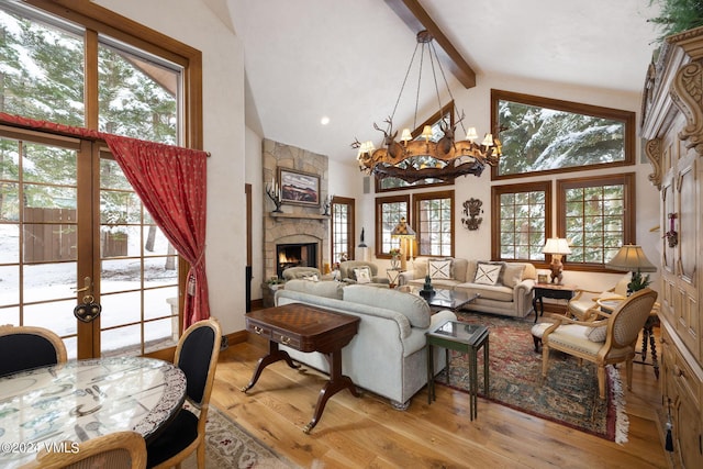 living room featuring beam ceiling, high vaulted ceiling, a stone fireplace, and light wood-type flooring