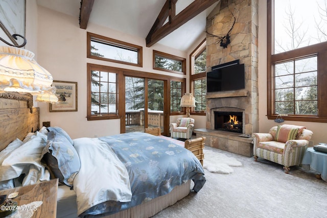 bedroom with beamed ceiling, a stone fireplace, high vaulted ceiling, and carpet