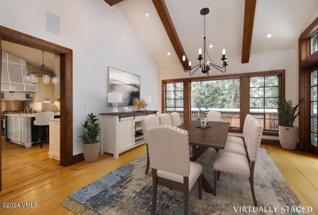 dining room with beamed ceiling, an inviting chandelier, high vaulted ceiling, and light wood-type flooring