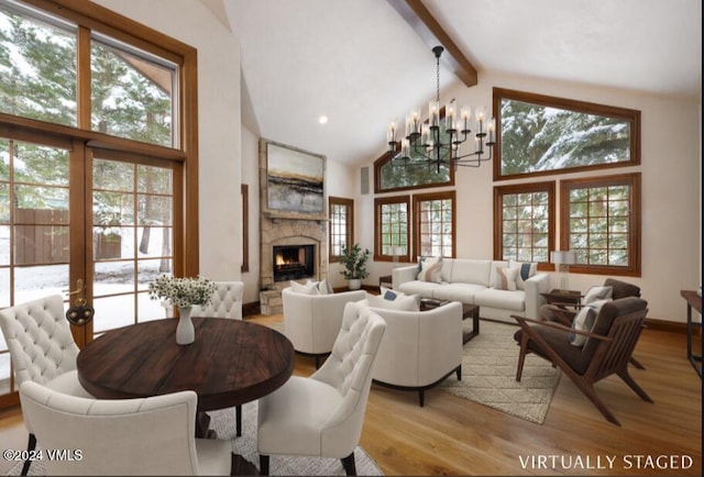 living room featuring a high end fireplace, light hardwood / wood-style flooring, high vaulted ceiling, and beamed ceiling