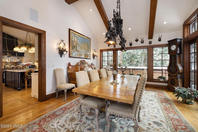 dining space featuring high vaulted ceiling, light hardwood / wood-style floors, and beamed ceiling