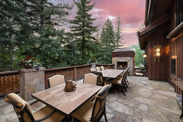 patio terrace at dusk with an outdoor stone fireplace