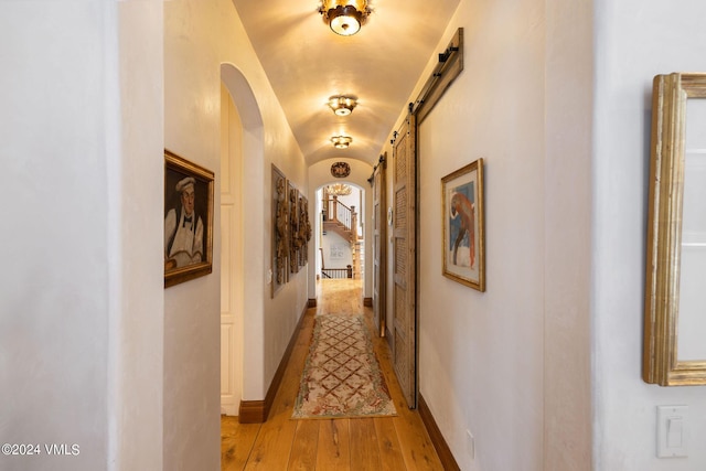 hall featuring lofted ceiling and light hardwood / wood-style floors