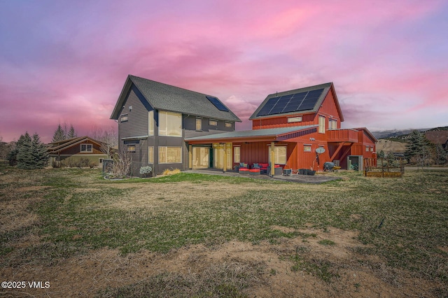 116 Thresher Ct, Eagle, CO 81631 - back of property with board and batten siding, a patio, roof mounted solar panels, and a lawn