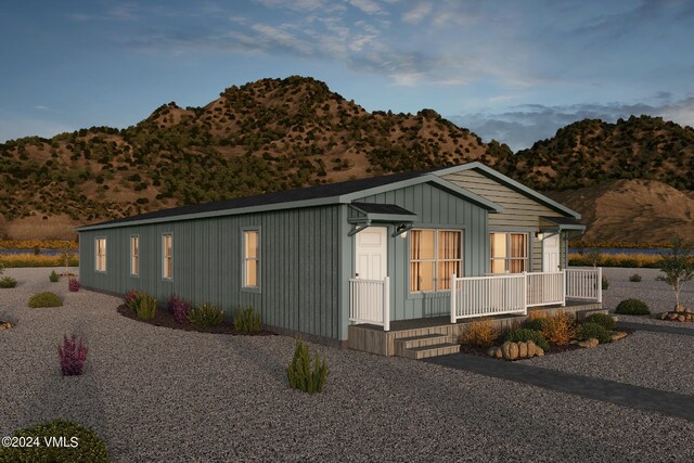 view of side of home with a mountain view and covered porch