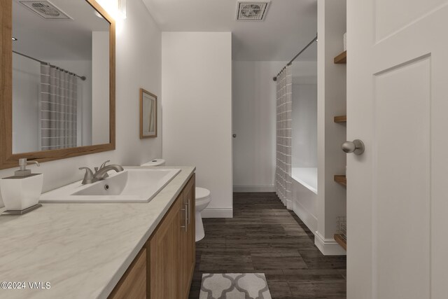 full bathroom featuring vanity, hardwood / wood-style flooring, toilet, and shower / tub combo with curtain