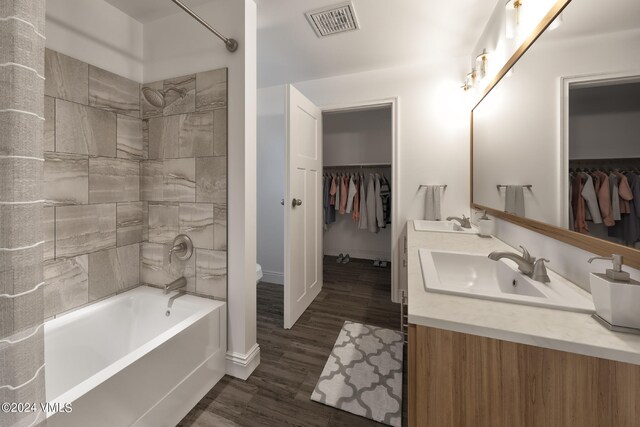full bathroom featuring vanity, toilet, tiled shower / bath combo, and hardwood / wood-style floors