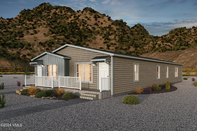 manufactured / mobile home featuring a mountain view and covered porch