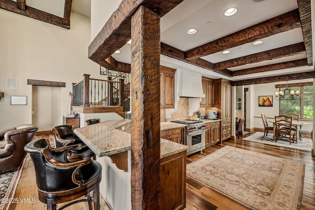 825 Forest Rd Unit 2, Vail, CO 81657 - kitchen featuring designer range, custom exhaust hood, hardwood / wood-style floors, a chandelier, and recessed lighting