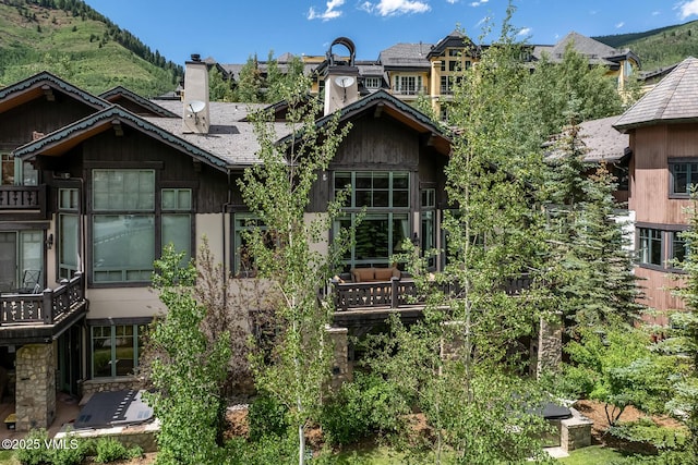 825 Forest Rd Unit 2, Vail, CO 81657 - view of home's exterior featuring a chimney, a mountain view, and a shingled roof