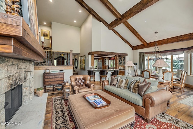 825 Forest Rd Unit 2, Vail, CO 81657 - living area with high vaulted ceiling, hardwood / wood-style floors, beamed ceiling, a chandelier, and a fireplace