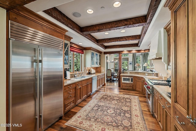 825 Forest Rd Unit 2, Vail, CO 81657 - kitchen with built in appliances, wood-type flooring, brown cabinets, ventilation hood, and glass insert cabinets