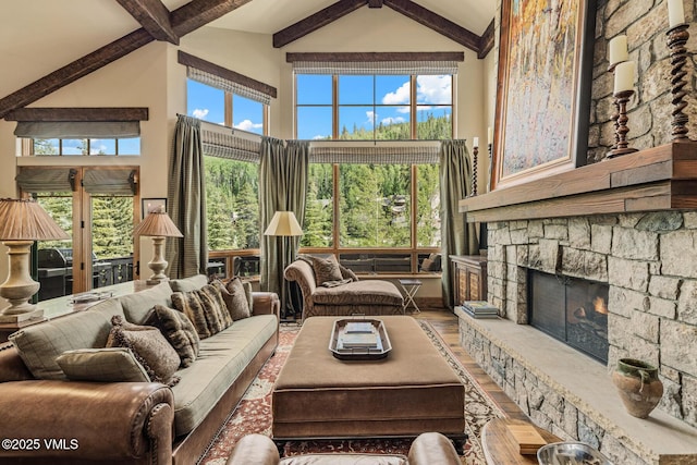 825 Forest Rd Unit 2, Vail, CO 81657 - living area featuring high vaulted ceiling, beamed ceiling, plenty of natural light, and a stone fireplace