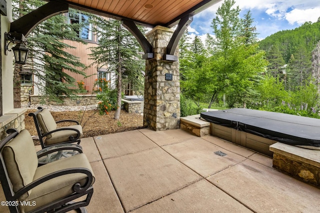 825 Forest Rd Unit 2, Vail, CO 81657 - view of patio / terrace featuring a covered hot tub and a view of trees