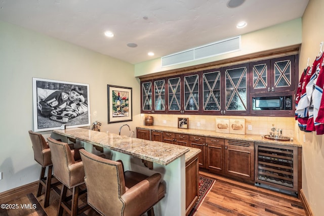 825 Forest Rd Unit 2, Vail, CO 81657 - indoor wet bar with wine cooler, backsplash, wood finished floors, recessed lighting, and black microwave