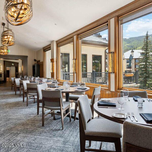 120 Offerson Unit 3430, Beaver Creek, CO 81620 - dining space featuring a chandelier, carpet, and vaulted ceiling