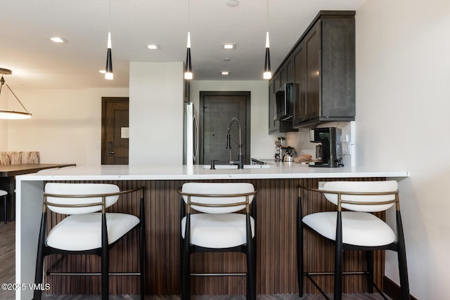 120 Offerson Unit 3430, Beaver Creek, CO 81620 - kitchen with light countertops, a peninsula, fridge, and dark brown cabinets