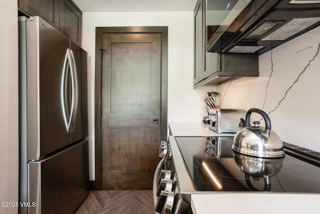 120 Offerson Unit 3430, Beaver Creek, CO 81620 - kitchen featuring freestanding refrigerator, electric range oven, dark brown cabinets, exhaust hood, and light countertops