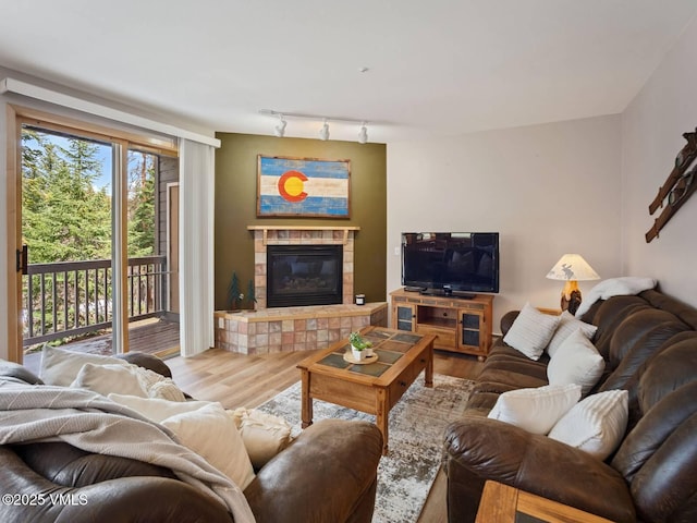 10000 Ryan Gulch Rd Unit 114, Silverthorne, CO 80498 - living room with wood finished floors, a tiled fireplace, and rail lighting