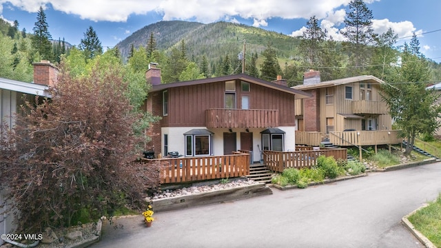 view of front facade with a deck with mountain view and a chimney