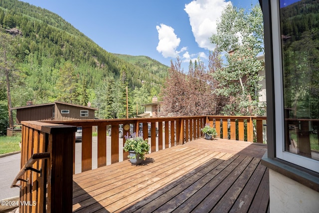 wooden deck with a mountain view and a wooded view