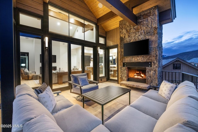 exterior space featuring wooden ceiling, beamed ceiling, high vaulted ceiling, and an outdoor stone fireplace