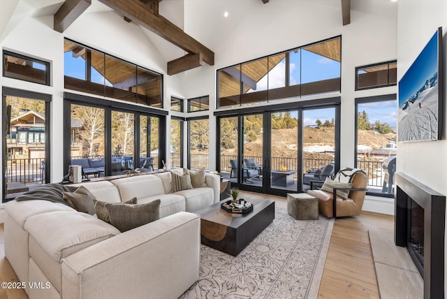 sunroom / solarium featuring lofted ceiling with beams and a fireplace