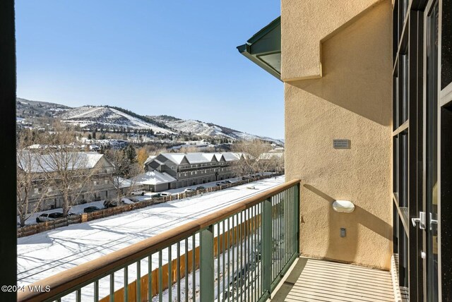 snow covered back of property featuring a mountain view