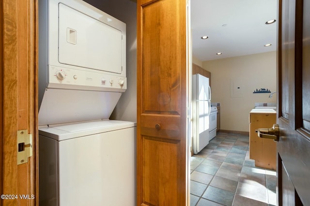 washroom with stacked washer / dryer and sink