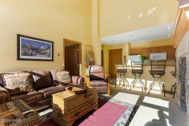 carpeted living room with a towering ceiling