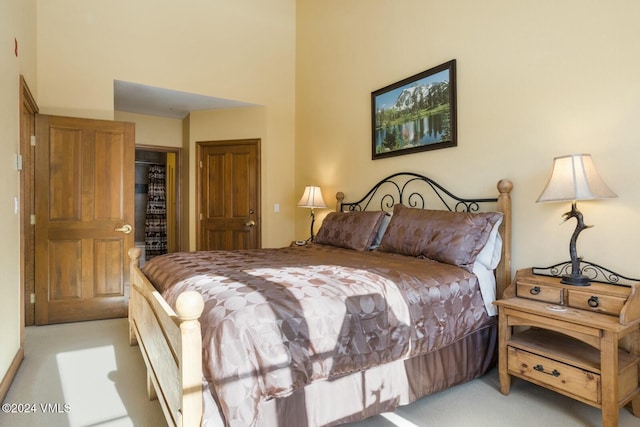 carpeted bedroom with a towering ceiling and a closet