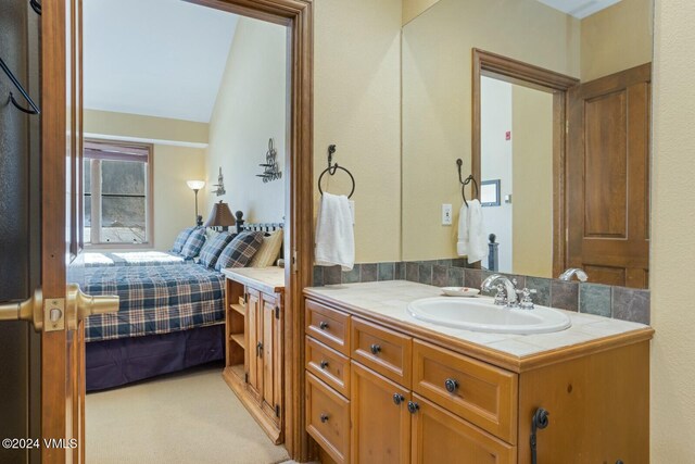 bathroom with vanity and lofted ceiling