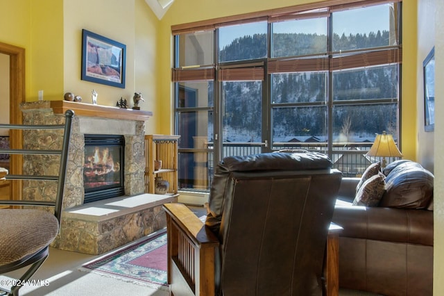 living room featuring vaulted ceiling, carpet floors, and a fireplace