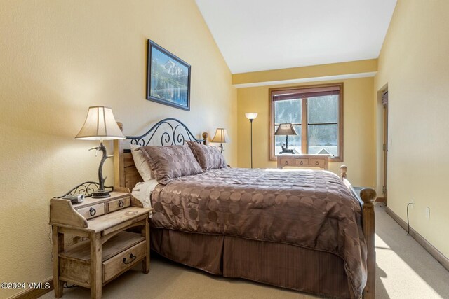 bedroom with light carpet and vaulted ceiling